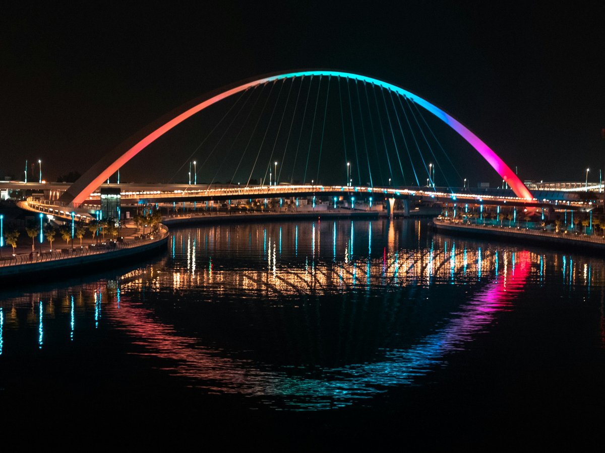 blue lighted bridge over water during night time