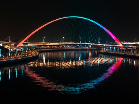 blue lighted bridge over water during night time