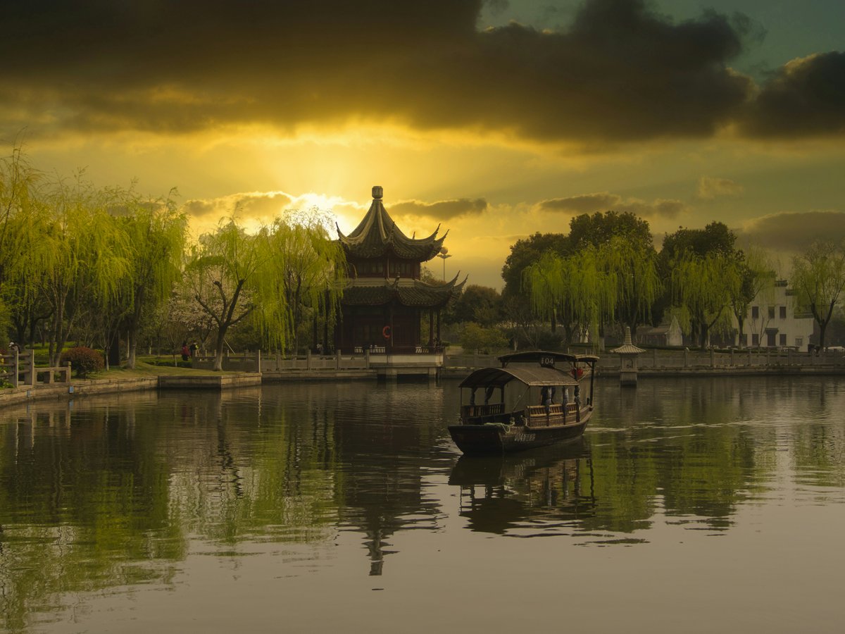 brown wooden house on lake during sunset
