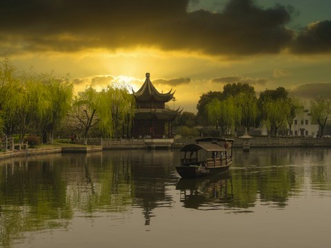brown wooden house on lake during sunset