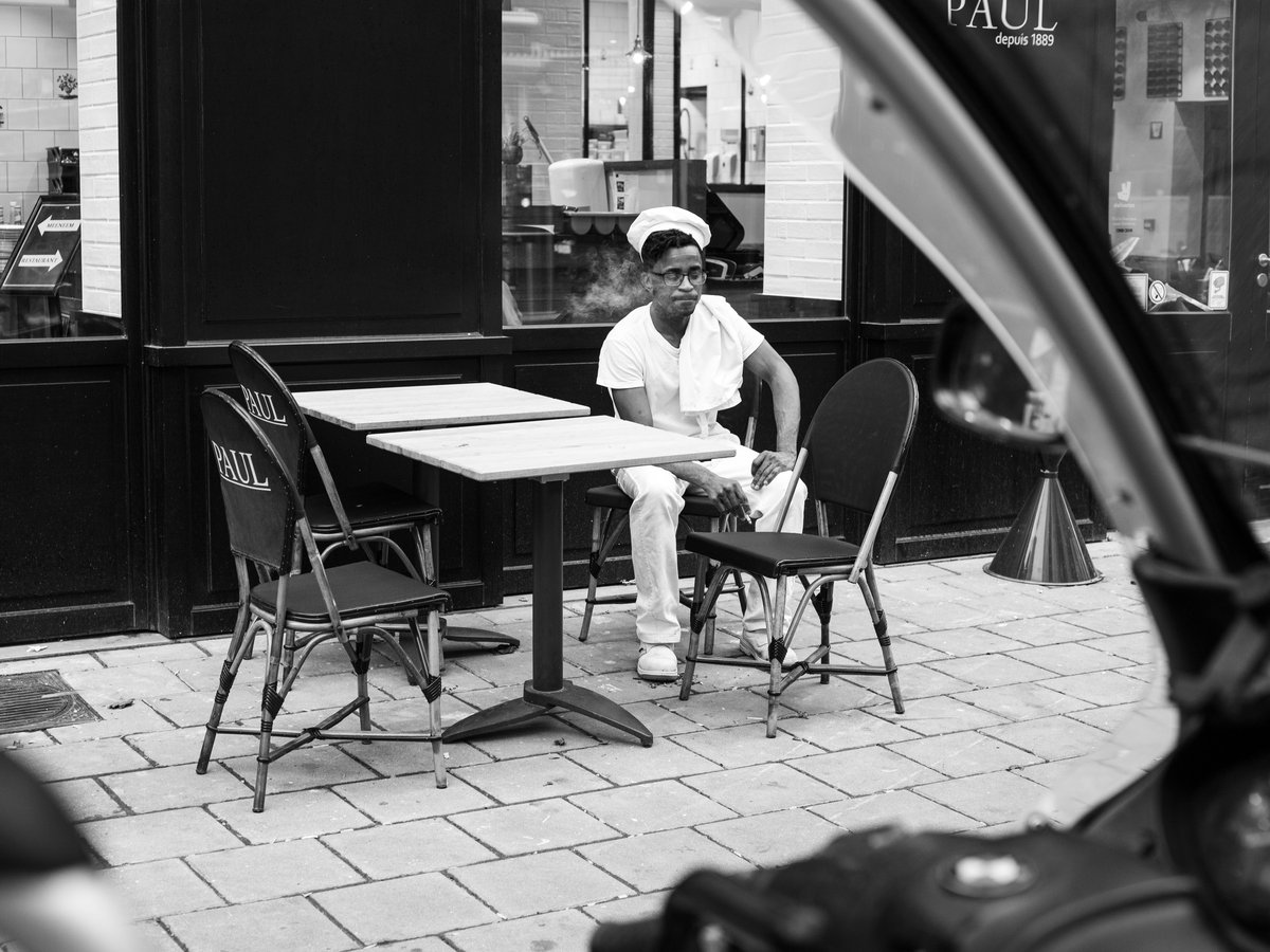 man in white dress shirt sitting on chair in grayscale photography
