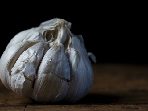 a white garlic on a wooden surface