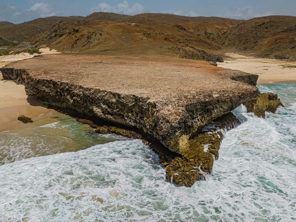 a large rock formation in the middle of a body of water