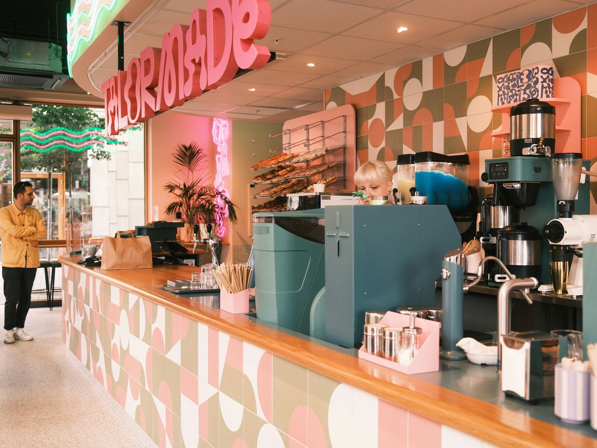 A coffee shop with a woman walking by the counter