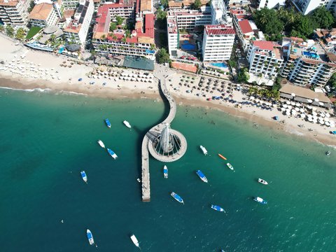 an aerial view of a beach with boats in the water