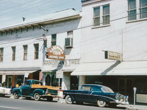 an old car is parked in front of a building