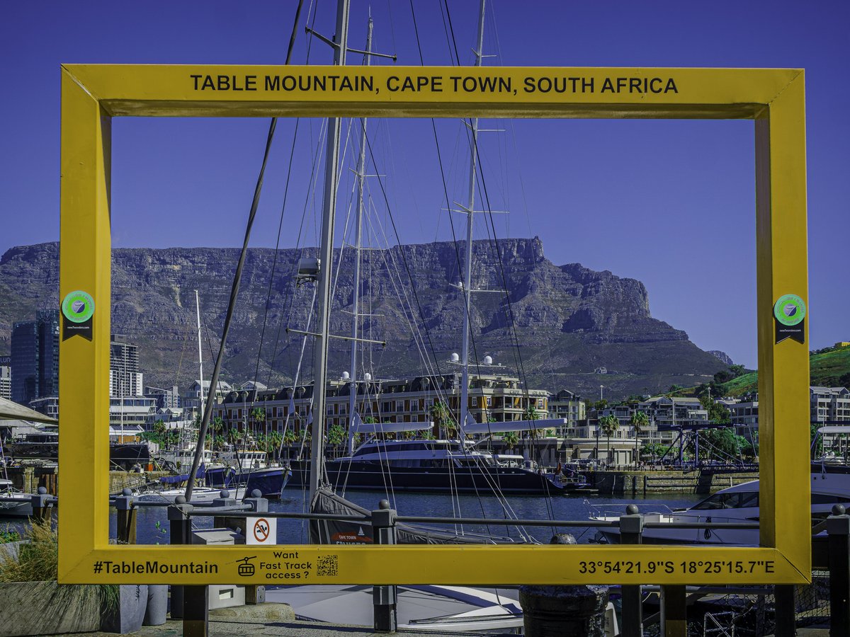 Table mountain framed by a yellow structure in cape town.