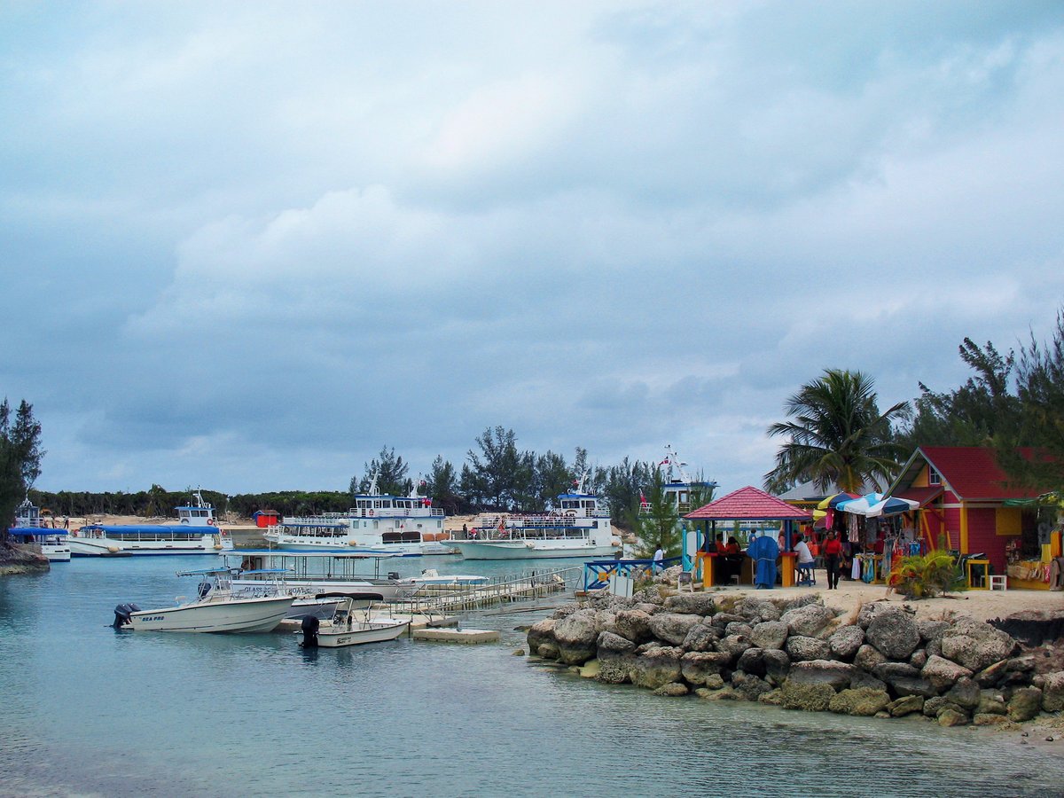 boats on body of water near houses on shore during day