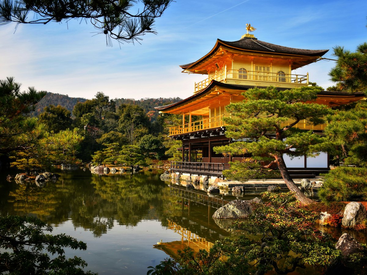 a pagoda in the middle of a lake surrounded by trees