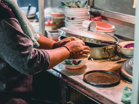 person in gray long sleeve shirt holding white ceramic bowl