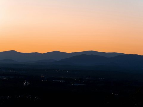 the sun is setting over the mountains in the distance