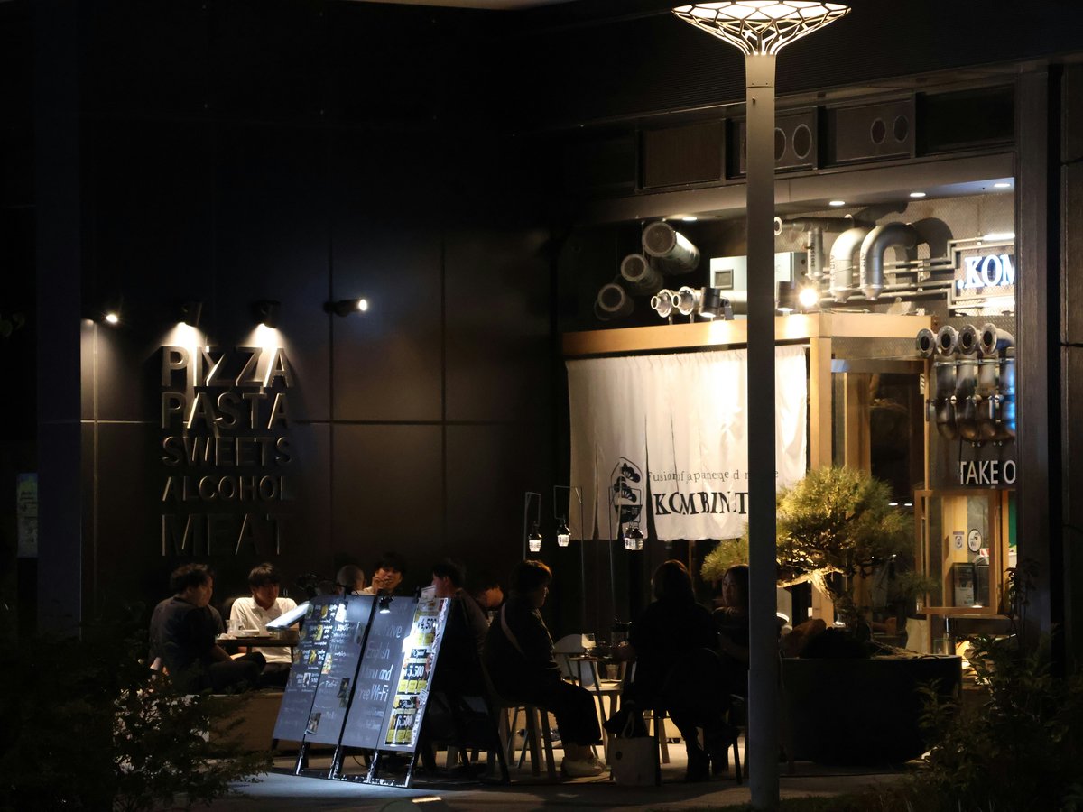 People dine at an outdoor cafe at night