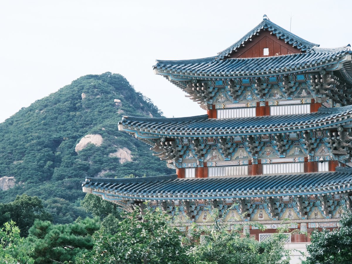 brown and white temple near green trees during daytime