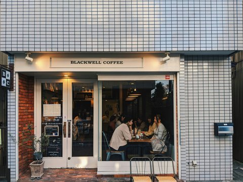 a group of people sitting at a table outside of a coffee shop