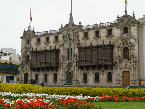 Ornate building with flags and flower garden