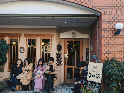 people sitting on bench near brown brick building during daytime