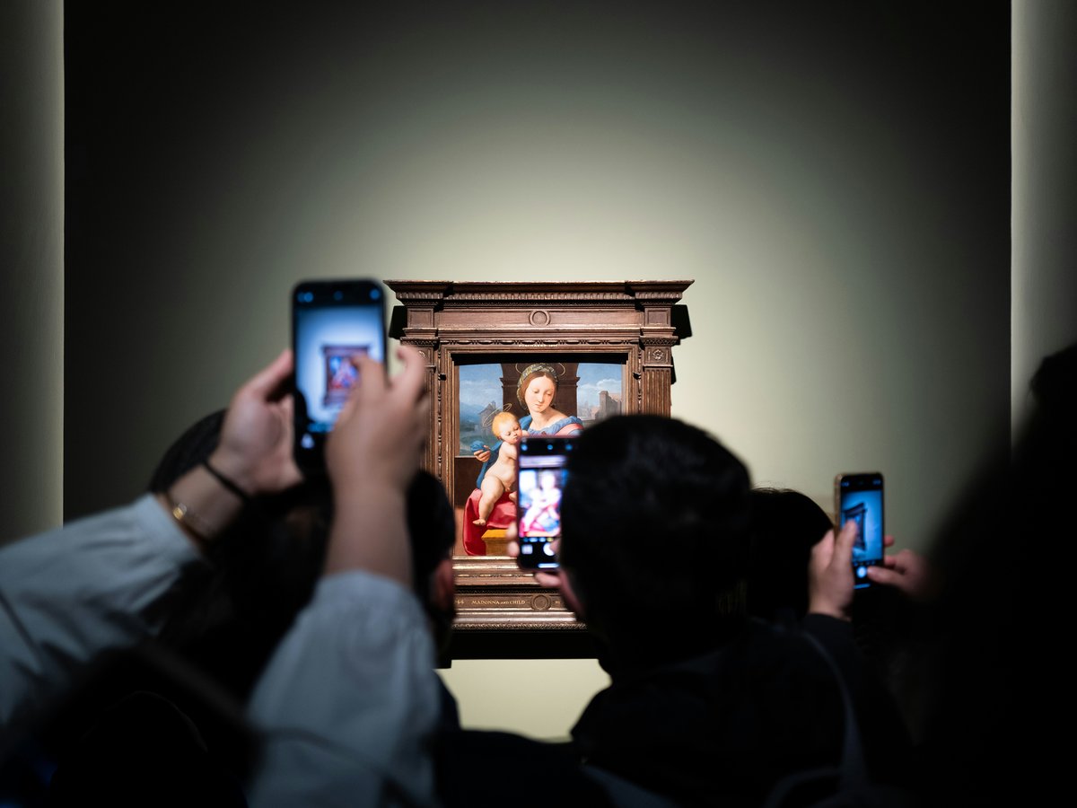 People take pictures of art at the gallery.