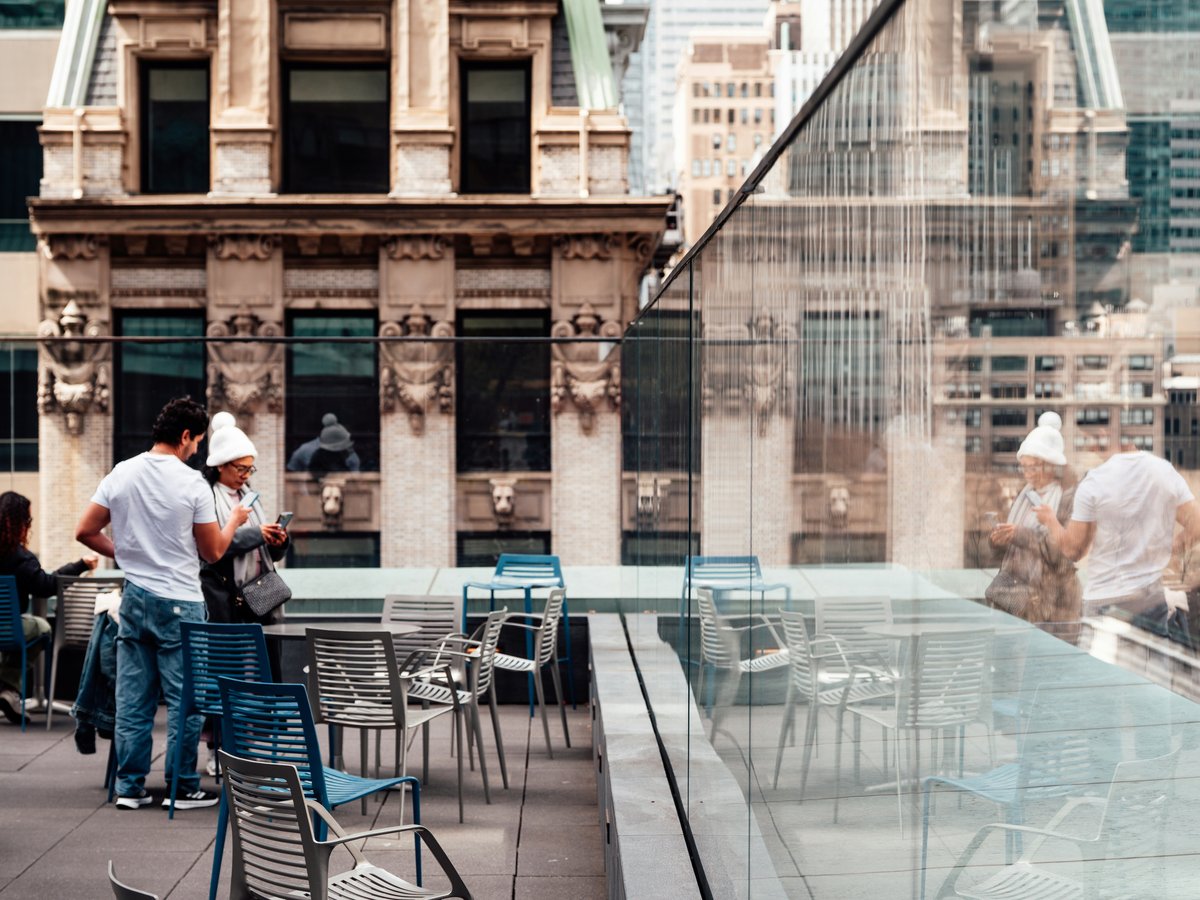 People enjoying a sunny day on an urban patio.