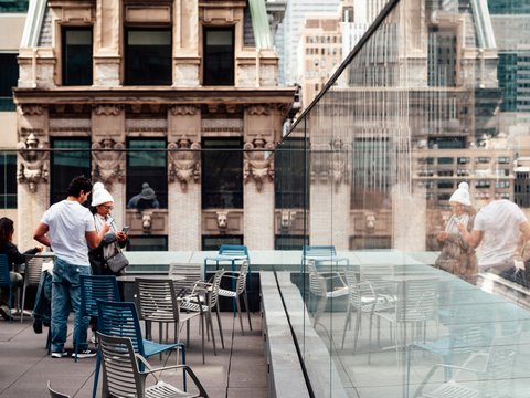 People enjoying a sunny day on an urban patio.