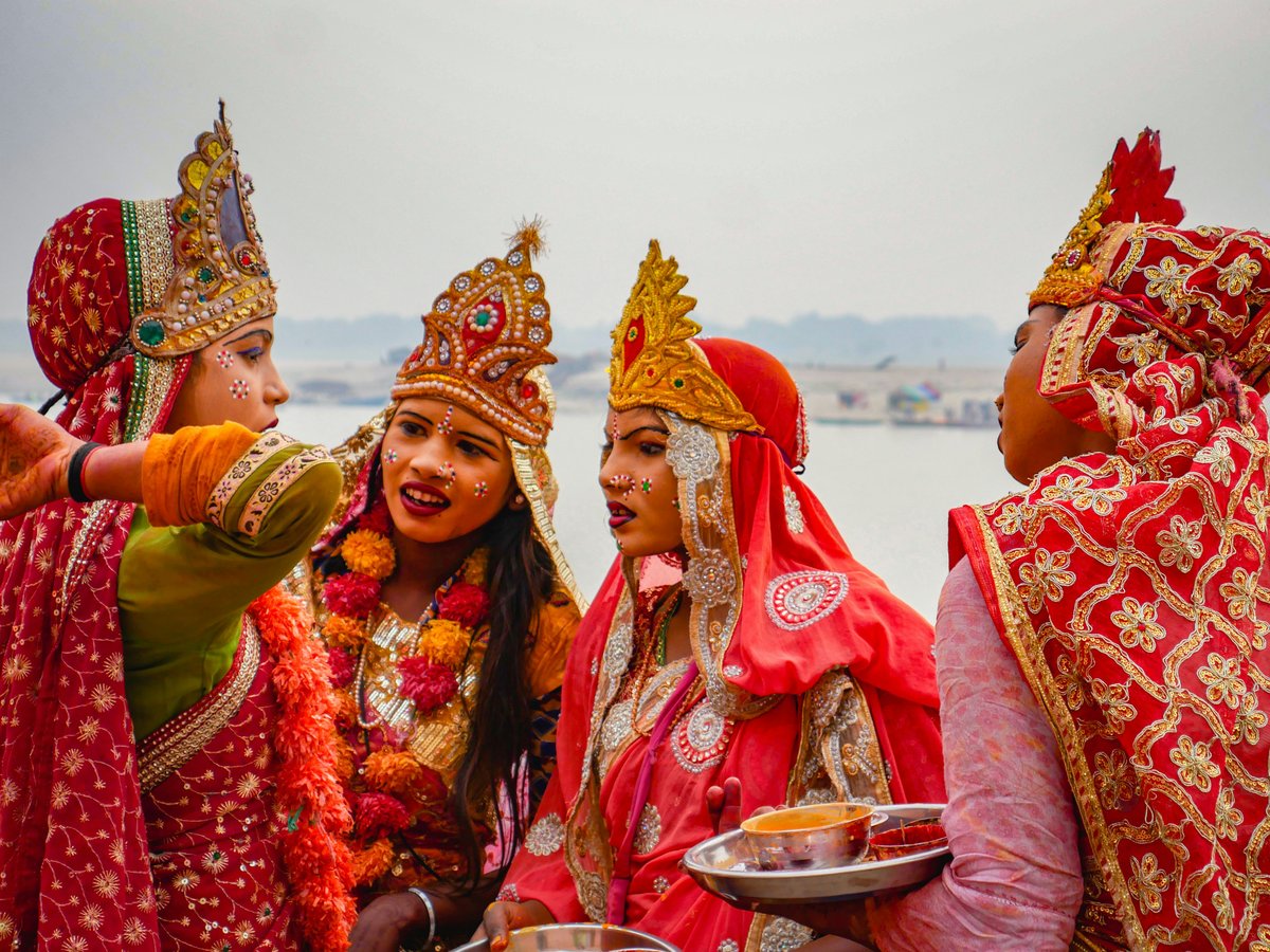 Four people in traditional indian attire by a river