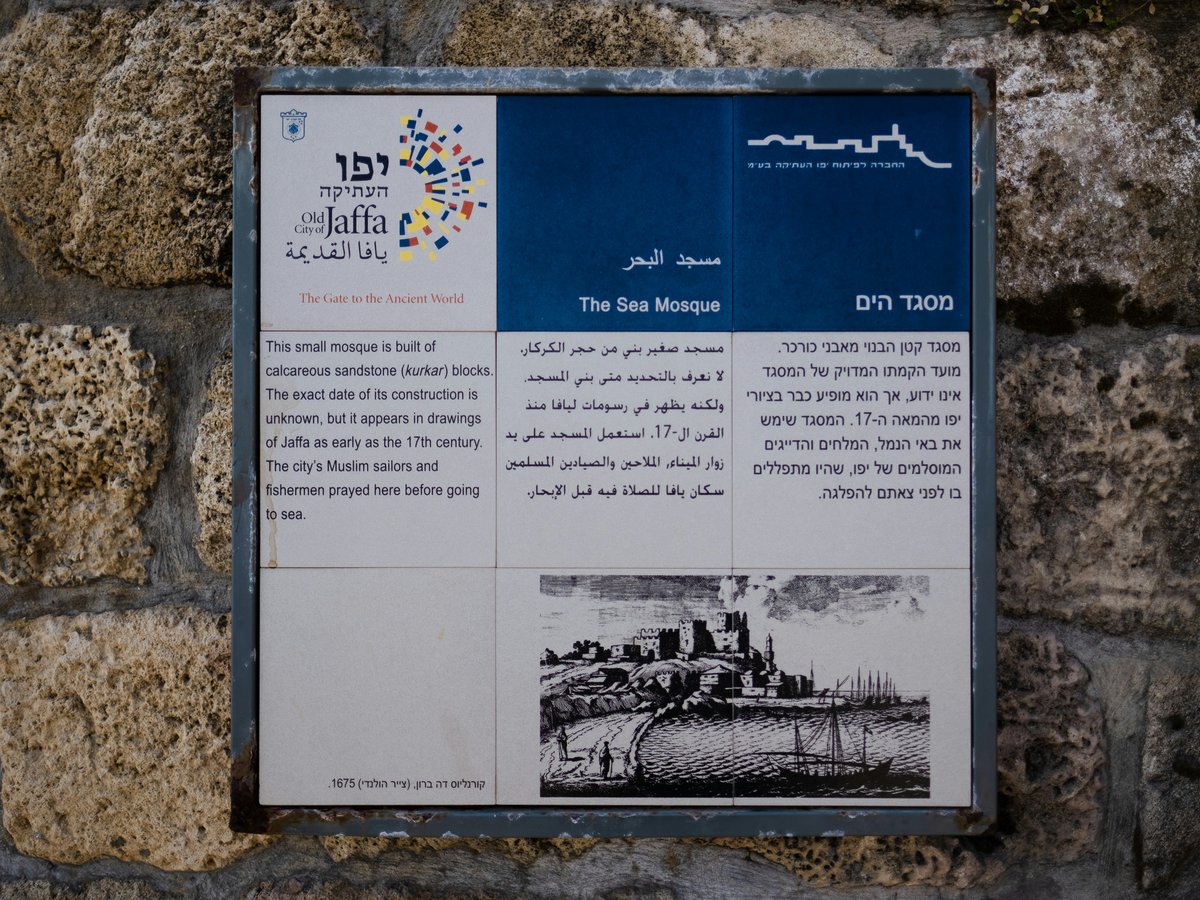 a sign on a stone wall with a picture of a city