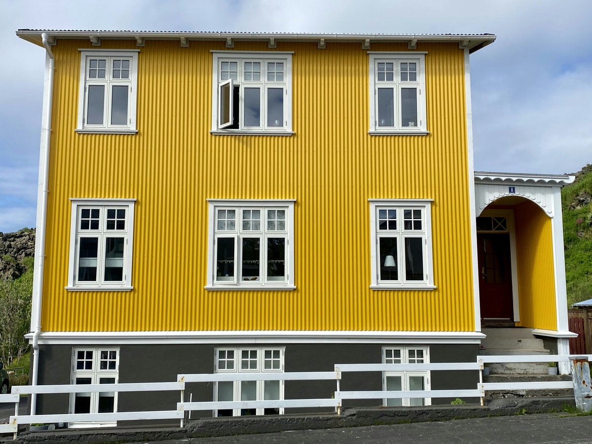 a yellow house with a fence