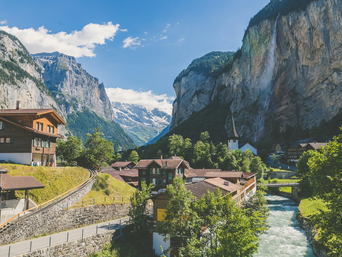 Wooden houses in the valley of Lauterbrunnen, Switzerland, with a waterfall and mountains