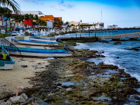 A group of boats sitting on top of a beach next to the ocean
