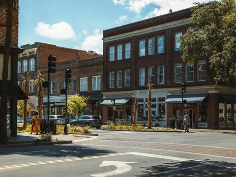 a street with a few people and buildings on the side
