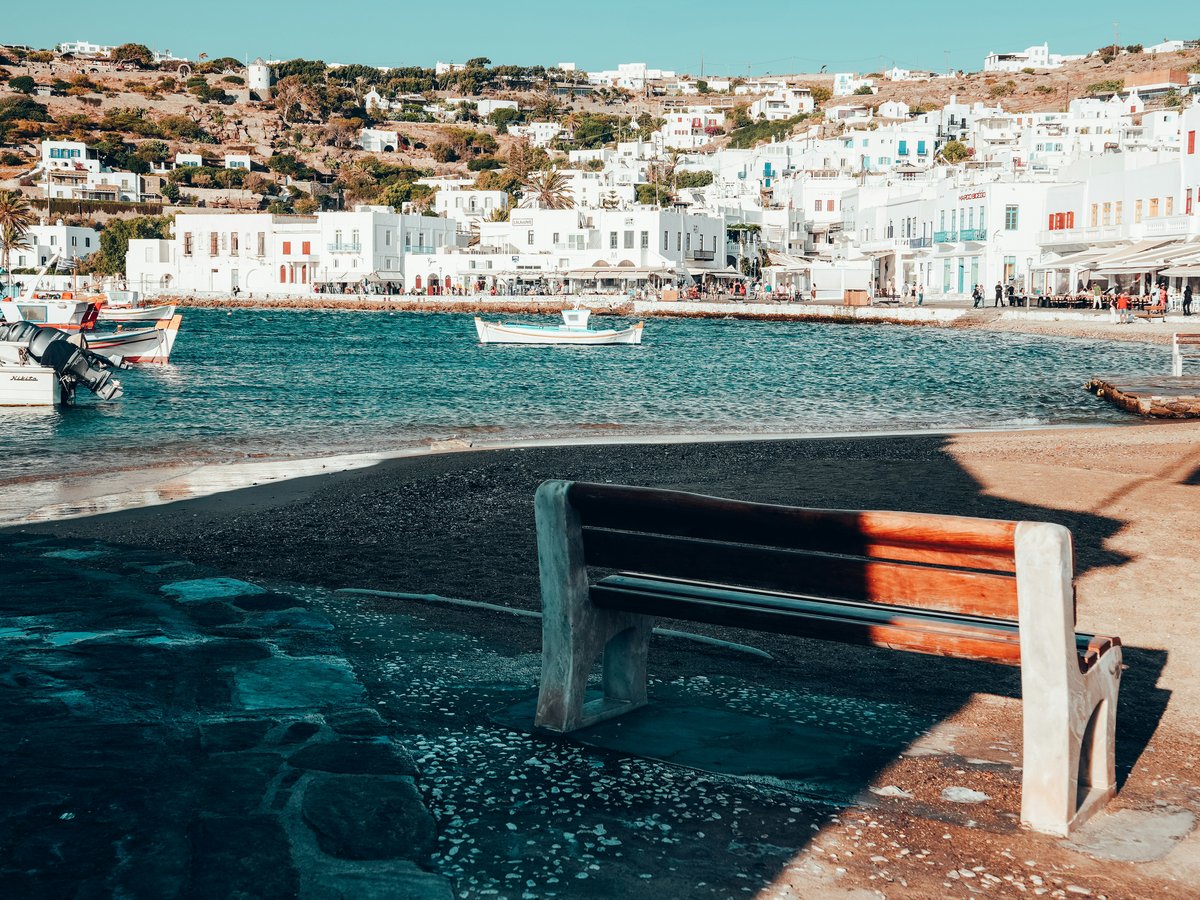 A wooden bench sitting on the side of a body of water