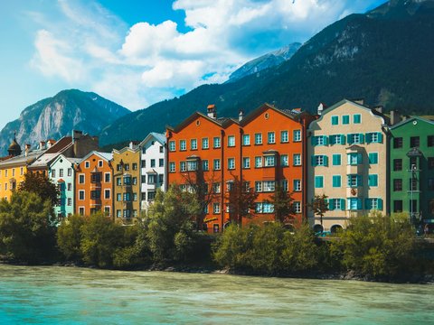 a body of water with buildings along it and mountains in the background