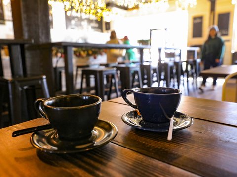 a cup of coffee sitting on top of a wooden table