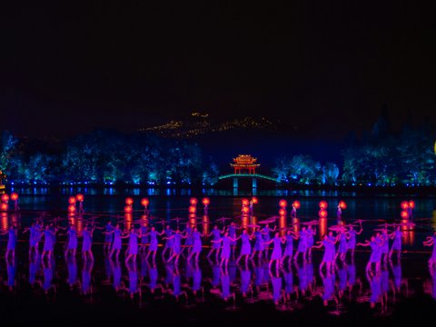 a large body of water surrounded by trees and lights