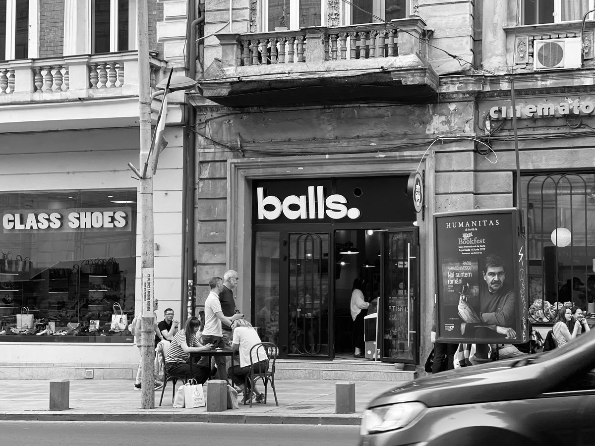 a black and white photo of people sitting outside of a store