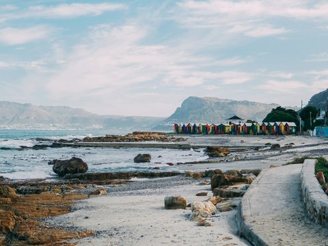 multicolored beach houses viewing mountain under white and blue sky during daytime