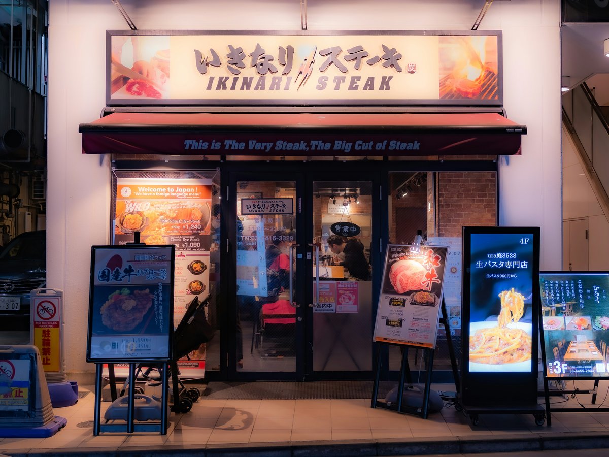 An ikinari steak restaurant storefront at night.