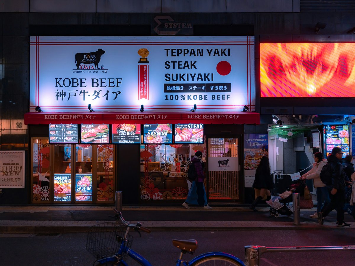 a group of people walking down a street at night