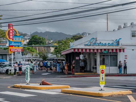 People queuing outside a store with a retro sign
