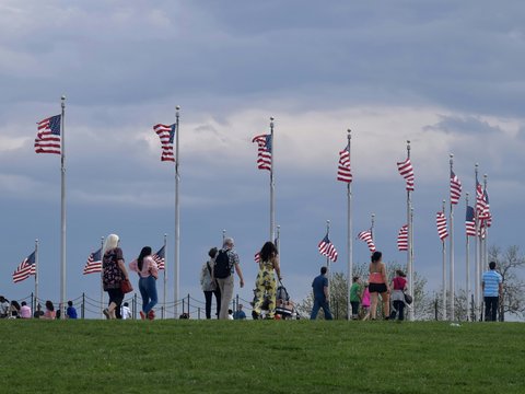 a group of people standing on top of a lush green field