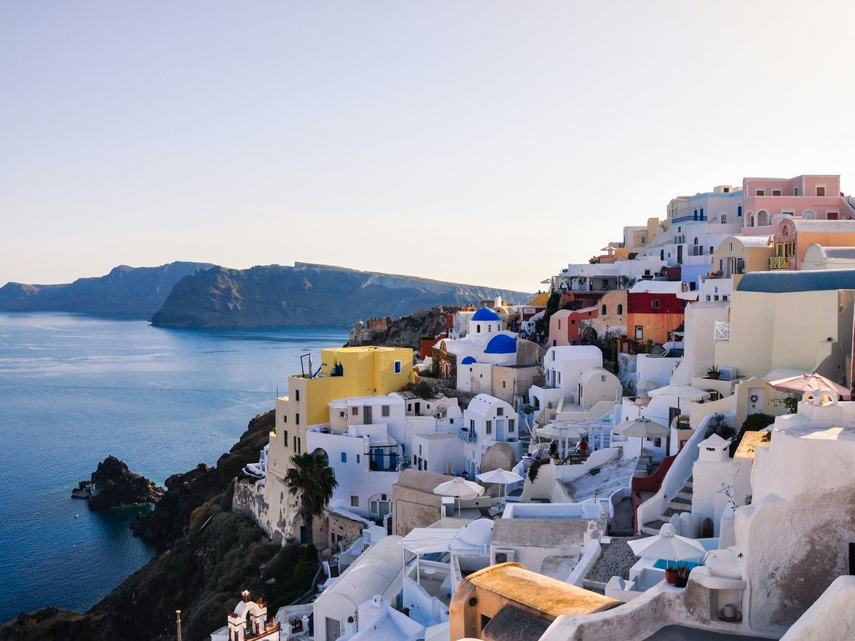 white and brown concrete houses near body of water during daytime