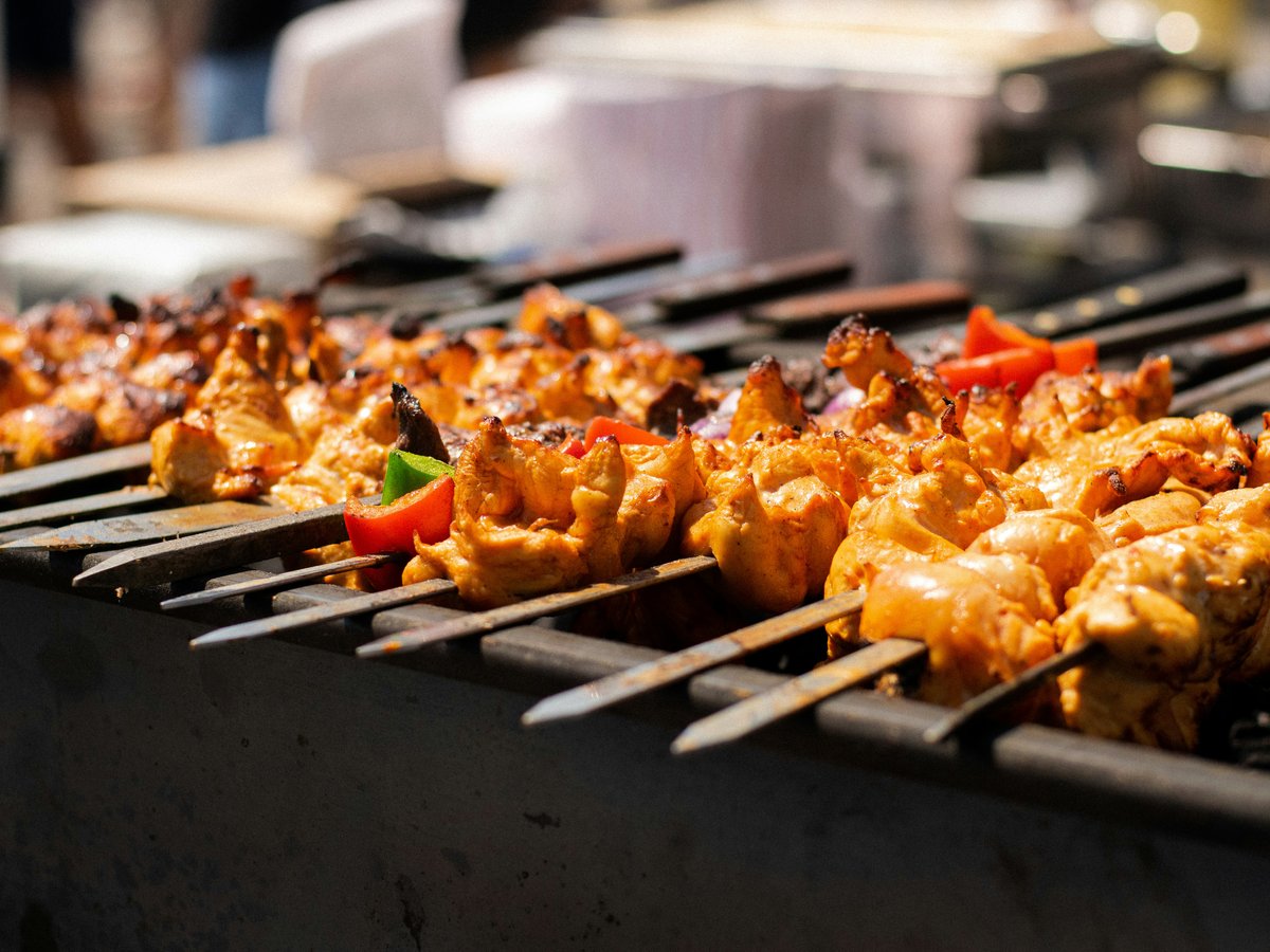 several skewers of chicken and vegetables on a grill