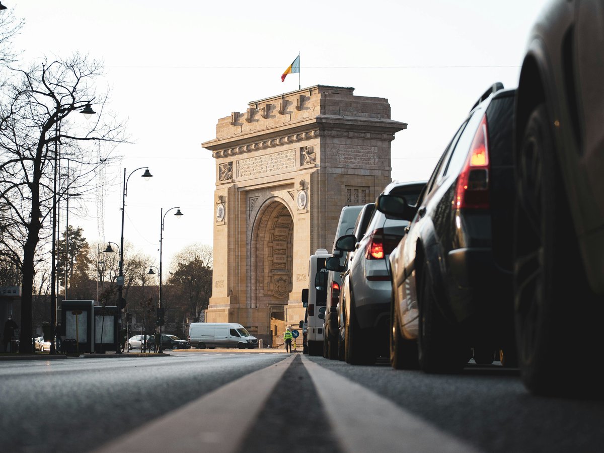 cars on road near brown concrete arch during daytime