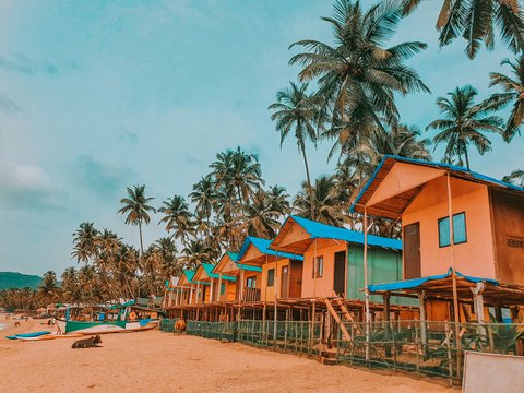 blue and brown wooden houses near palm trees under blue sky during daytime