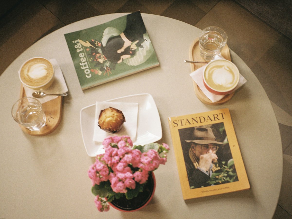A table topped with a white table top covered in books