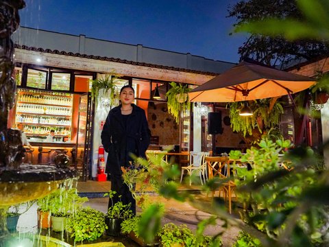 Man poses outside of a restaurant at night.
