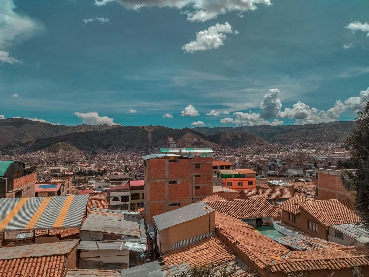 a city with many rooftops and mountains in the background