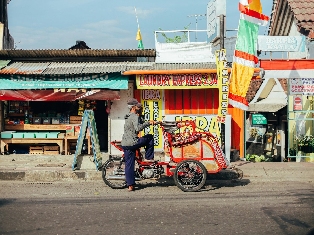 man in blue shirt riding on red and black motorcycle during daytime