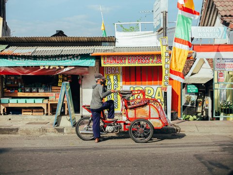 man in blue shirt riding on red and black motorcycle during daytime