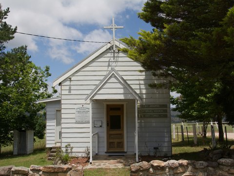 Small white chapel with a cross on top.