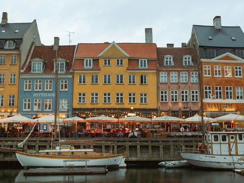 Colorful buildings line a canal with boats.